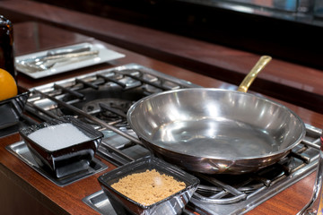 empty sauce pan on the gas stove near with dessert ingredient