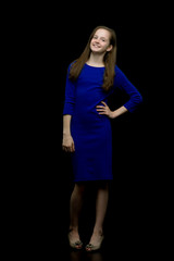 Fashionable girl teenager studio photo on a black background.