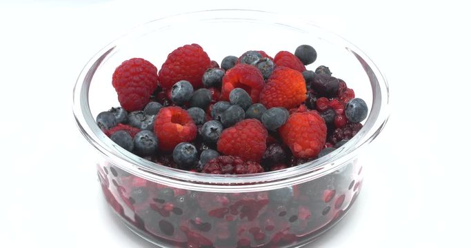Various colourful berries in glass blow rotation on white background, strawberry, raspberry, blackberry, blueberry, healthy food concept.