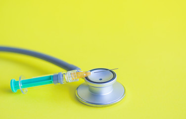 Injection needle with stethoscope   put on yellow background. Concept Prevent HPV infection by...