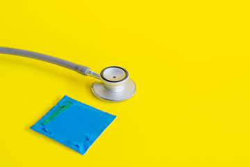 Condom and   Stethoscope  Placed on a yellow background. Concept    Safe sex and  check for...