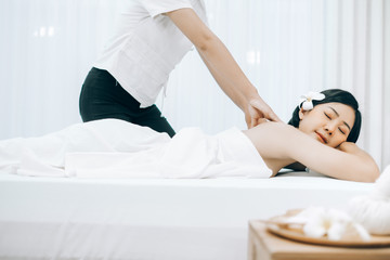 Obraz na płótnie Canvas Beautiful young woman lying down on beds massage and spa at asian spa massage and beauty salon center, spa concept, massage concept
