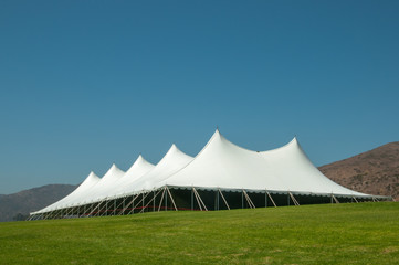 Large white tent for events in a green field
