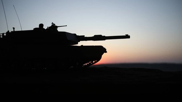 War Concept. Military silhouettes fighting scene on war foggy sky background at sunset. Armored vehicles with soldiers ready to attack. Artwork decoration. Selective focus