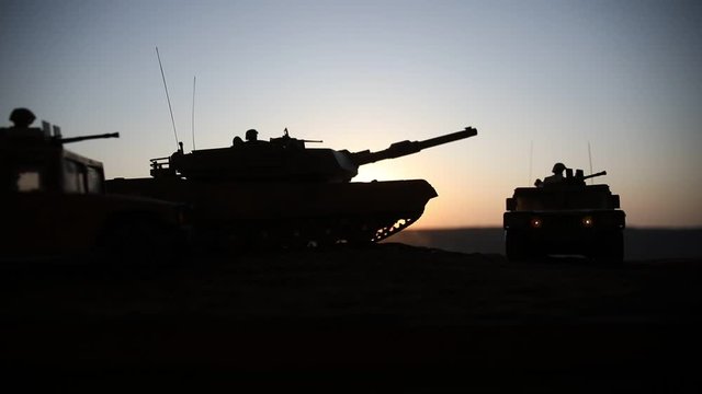 War Concept. Military silhouettes fighting scene on war foggy sky background at sunset. Armored vehicles with soldiers ready to attack. Artwork decoration. Selective focus