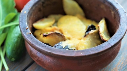 close up view on baked potatoes with cheese in aged earthware