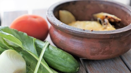 side close up view in a bowl with roasted potato and green salad
