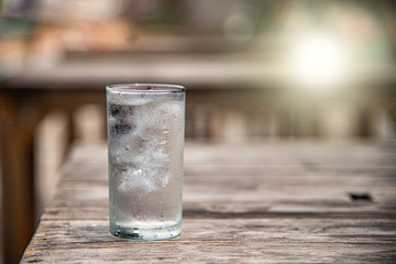 A glass of water placed on a wooden table