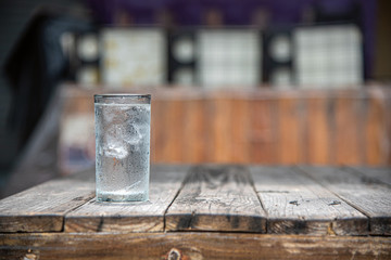 A glass of water placed on a wooden table