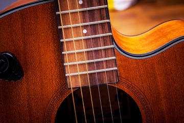Obraz premium Strings on the fretboard of an acoustic guitar. Closeup