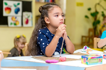 little girl in a drawing lesson in kindergarten