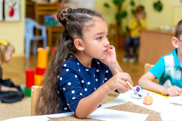 little girl in a drawing lesson in kindergarten