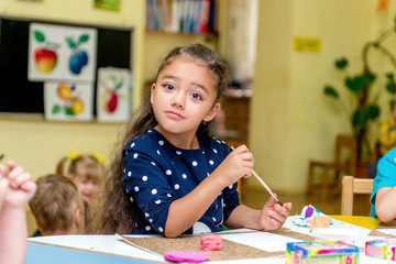 little girl in a drawing lesson in kindergarten