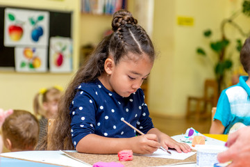 little girl in a drawing lesson in kindergarten