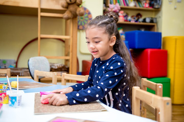 little girl in a drawing lesson in kindergarten