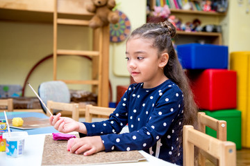 little girl in a drawing lesson in kindergarten