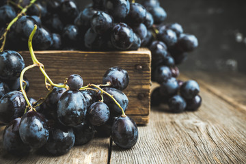 Ripe black grape on the rustic background. Selective focus. Shallow depth of field.