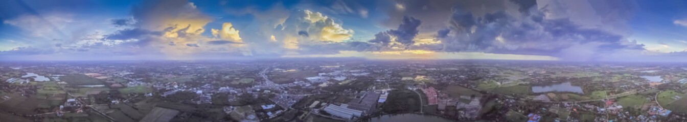 Aerial view panorama 360 degree above green rice fields, village, and reservoir with cloudy sky background, Krajub reservoir in Ban Pong, Ratchaburi, Thailand.