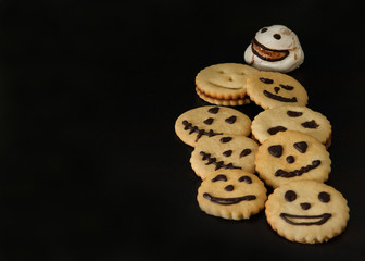 Homemade cakes for Halloween. Horrible and evil ghosts meringue cookies with scary smiles on black background. Free space for your text.