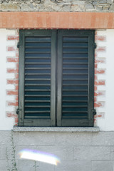 Closed wooden frame window in a stone wall, 