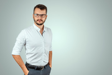 Fototapeta premium Portrait of a young male teacher on a light background. Teacher's Day Knowledge Day back to school study online learning.