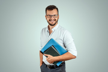 Portrait of a young male teacher on a light background. Teacher's Day Knowledge Day back to school study online learning.