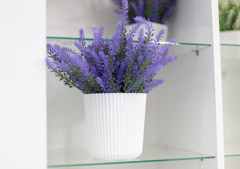 artificial blue flower in a plastic pot on the table