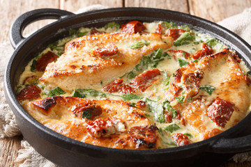 Italian chicken breast with sun-dried tomatoes and spinach in cheese sauce close-up in a pan. horizontal