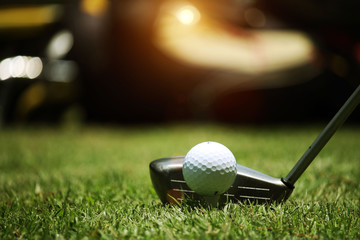 golf club and golf ball close up in grass field with sunset. Golf ball close up in golf coures