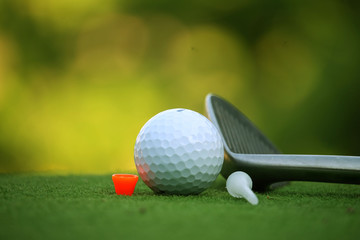 Golf ball and golf club in the evening golf course with sunshine in thailand