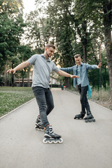 Roller skating, two skaters rolling in summer park