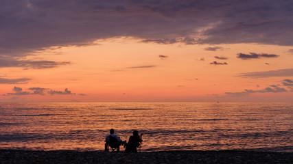 Couple relaxing and looking at sunset