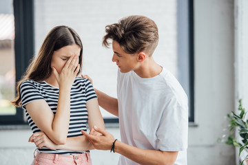 teen boy in white t-shirt supporting crying friend
