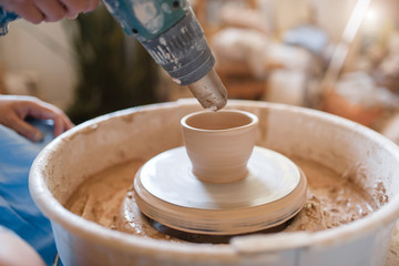 Master dries a pot on pottery wheel