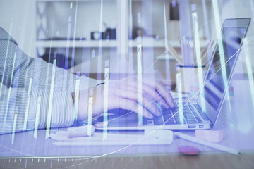Double exposure of stock market graph with man working on laptop on background. Concept of financial analysis.