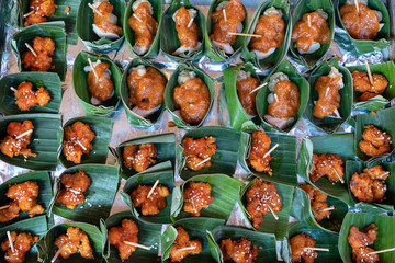 Fototapeta na wymiar Traditional indonesian snack in green palm leaves . Close up. Asian food background, buffet table
