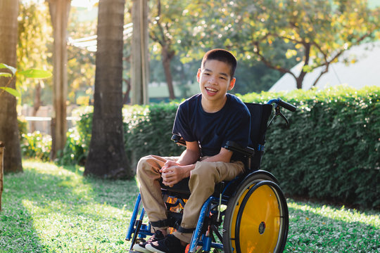 Disabled Child On Wheelchair Is Playing, Learning And Exercise In The Outdoor City Park Like Other People,Lifestyle Of Special Child,Life In The Education Age Of Children,Happy Disability Kid Concept.