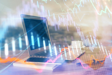 Stock market graph on background with desk and personal computer. Double exposure. Concept of financial analysis.