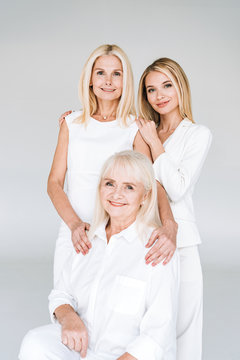 beautiful three generation blonde women isolated on grey