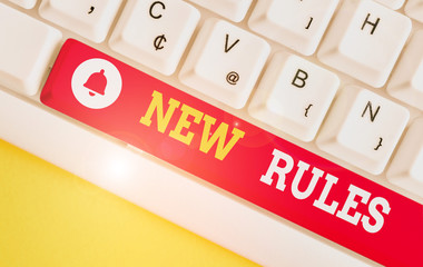 Text sign showing New Rules. Business photo showcasing A state of changing an iplemented policy for better upgrade White pc keyboard with empty note paper above white background key copy space