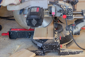 Slicing the boards on a circular saw. Construction of wooden houses.