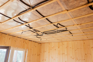 Electrical wires on the ceiling of a wooden house. Construction. Electrician.