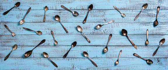 Vintage cutlery - spoons, forks and knives on an old wooden background.