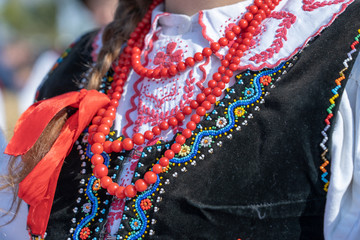 Colorful clothes with beads on at young girls during a festival in Ukraine. Closeup