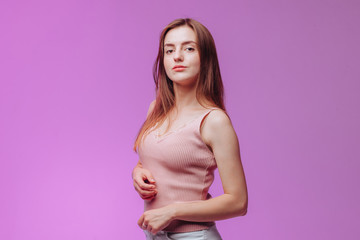 Fototapeta na wymiar Portrait of a girl in a pink t-shirt on a purple background