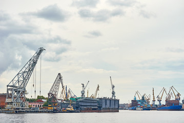 Fototapeta na wymiar working crane bridge in shipyard and cargo ships in a port