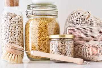 Glass jars with food ingredients on a white background. Zero waste concept. Kitchen background with...