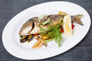 Baked dorado with butter and vegetables.