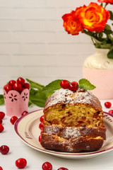 Cupcake with sweet cherry with a cut is located on a white background, vertical orientation