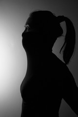 silhouette portrait of long hair covering face woman in the dark mystery concept